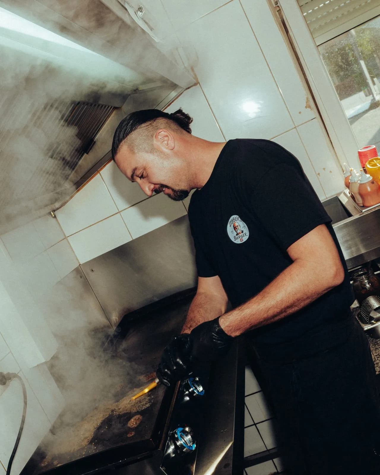 Koch an der Plancha bei Zeybeks Burger, Dampf steigt auf